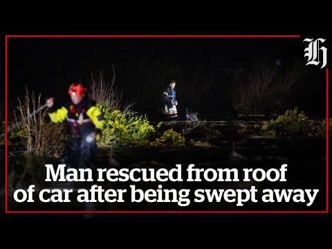 Man rescued from roof of car after being swept away